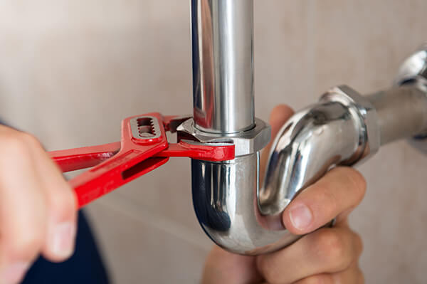 plumber-fixing-pipe-with-tool